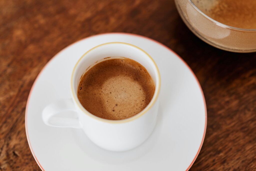 Aromatic espresso served in a white ceramic cup on a wooden table, perfect for coffee enthusiasts.